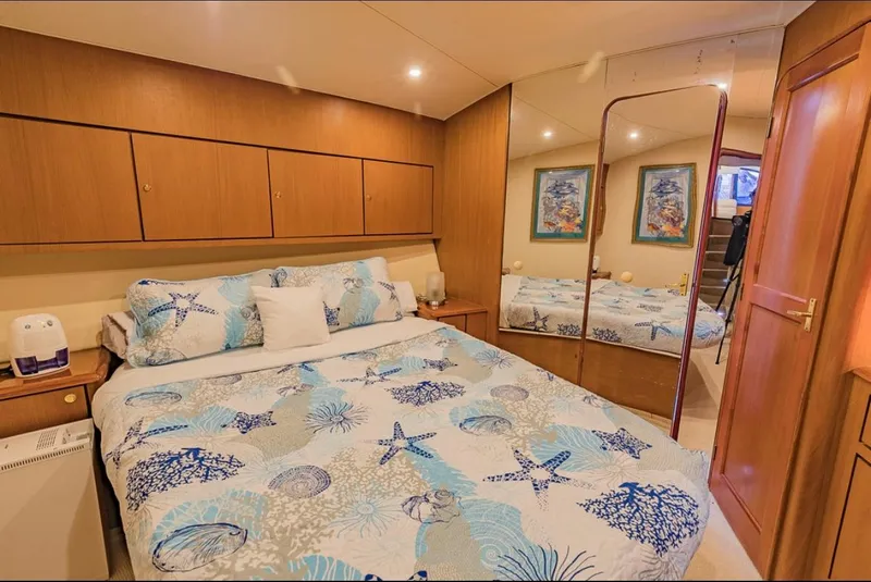 Slide: The Image of Luxurious bedroom in 1999 Ocean Yachts 60 Convertible with nautical-themed bedding. - 24