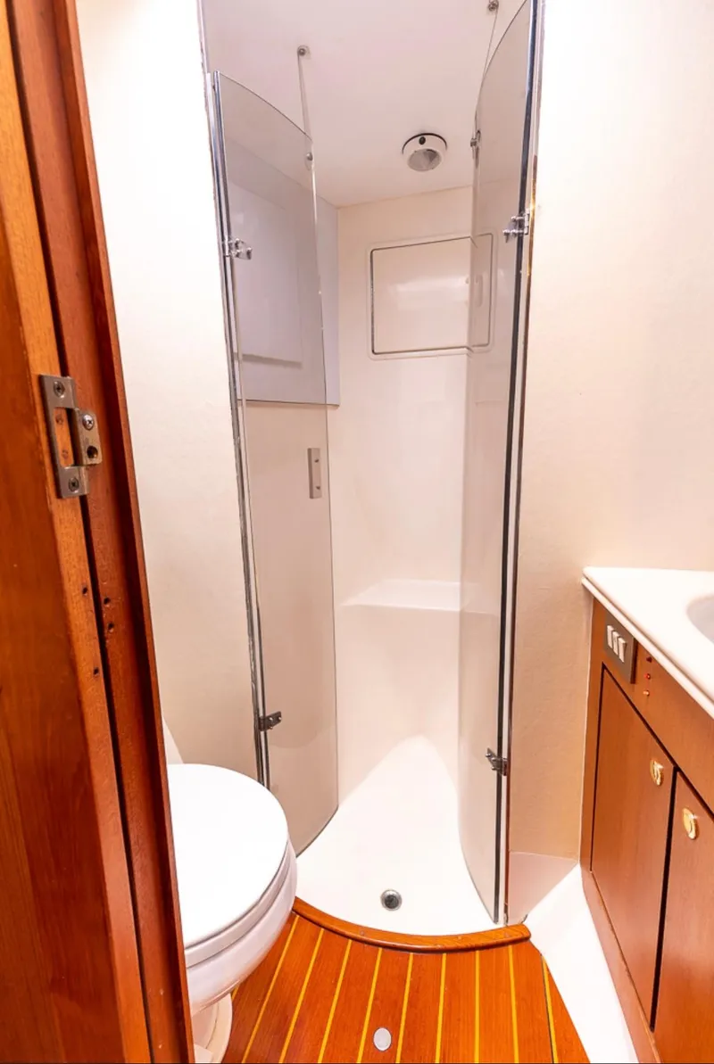Slide: The Image of 1999 Ocean Yachts 60 Convertible bathroom with shower, wooden flooring, and modern fixtures. - 25