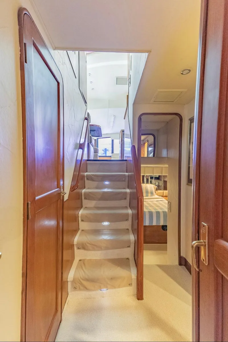 Slide: The Image of Interior view of 1999 Ocean Yachts 60 Convertible, featuring wooden stairs and cozy cabin. - 26