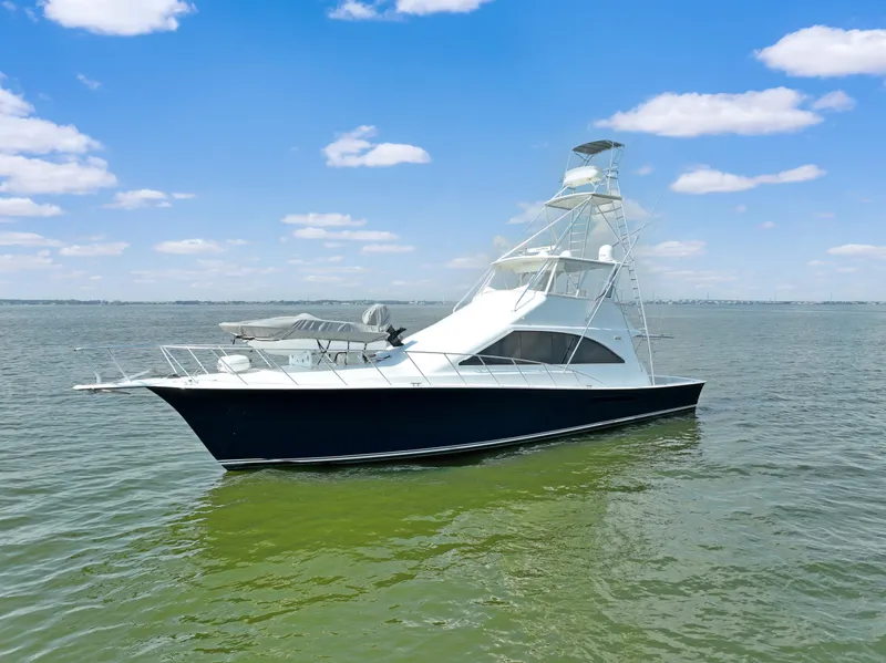 Slide: The Image of 1999 Ocean Yachts 60 Convertible boat on calm water under blue sky. - 3