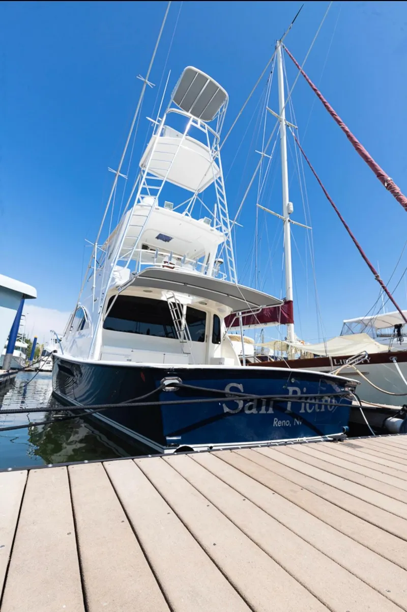 Slide: The Image of 1999 Ocean Yachts 60 Convertible docked at marina under clear blue sky. - 5