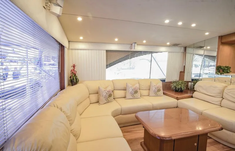 Slide: The Image of Luxurious interior of 1999 Ocean Yachts 60 Convertible with beige seating and wooden table. - 9