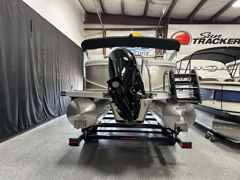 Slide: The Image of 2025 Barletta Cabrio 22QC pontoon boat in showroom, featuring sleek design and Mercury outboard motor. - 2