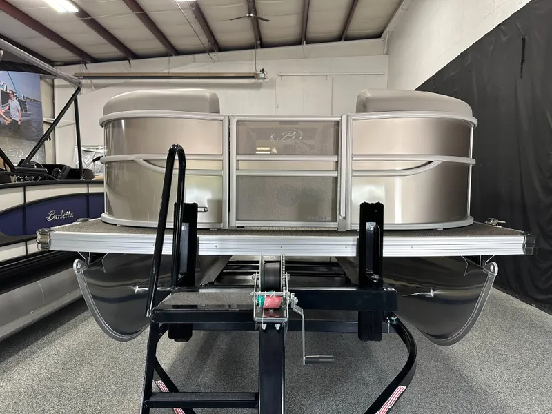Slide: The Image of 2025 Barletta Cabrio 22QC pontoon boat in showroom, rear view with motor and ladder. - 5