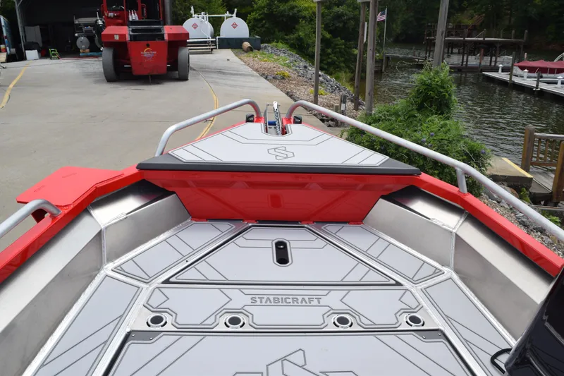 Slide: The Image of Stabicraft 1550 Frontier Profish 2025 boat deck with red accents, dockside view. - 13