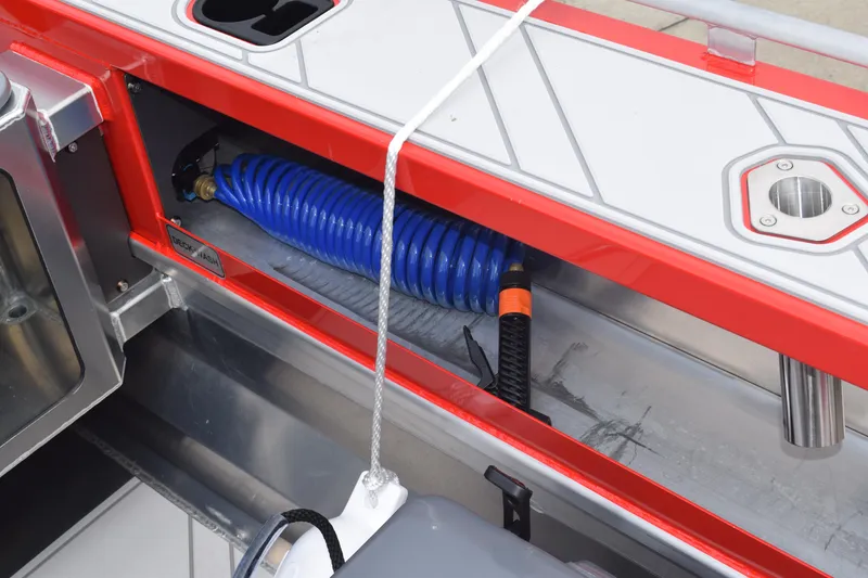 Slide: The Image of 2025 Stabicraft 1550 Frontier Profish boat storage compartment with coiled blue hose. - 17