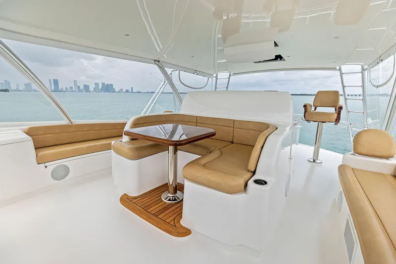 Slide: The Image of 2018 Viking 80 Convertible yacht interior with seating and table, ocean view. - 12