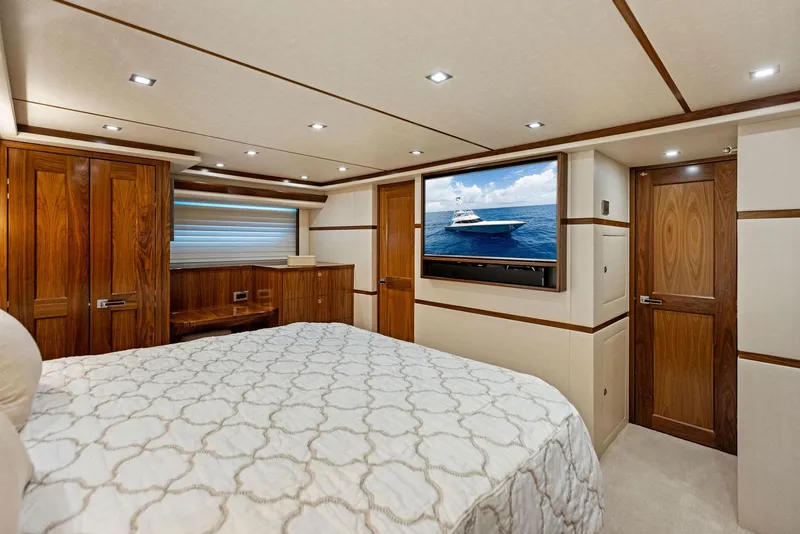Slide: The Image of Luxurious bedroom interior of 2018 Viking 80 Convertible yacht with wood accents and flat-screen TV. - 22