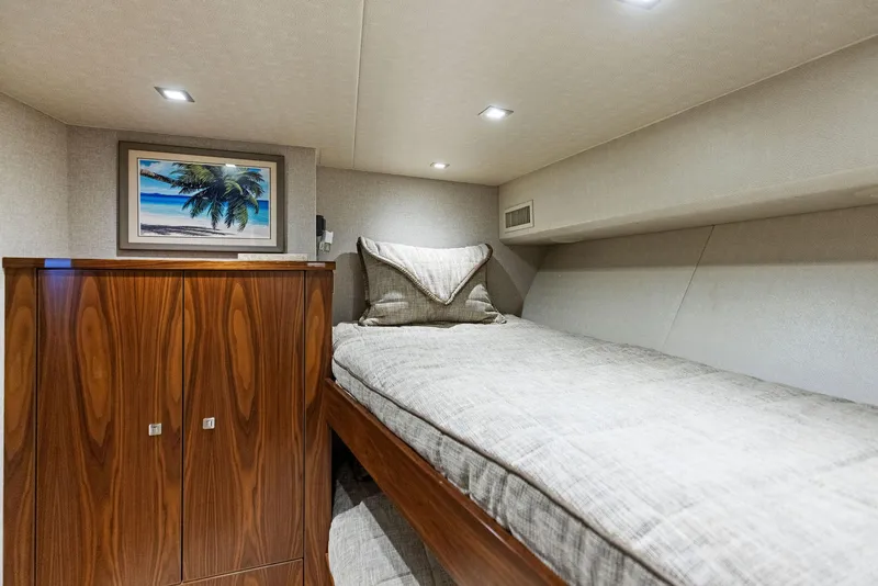 Slide: The Image of Cozy cabin interior of 2018 Viking 80 Convertible yacht with single bed and wooden cabinet. - 26