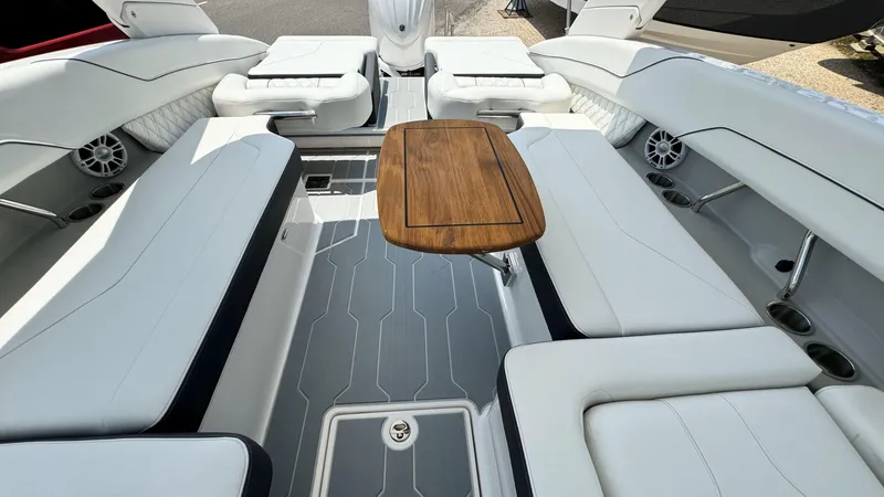 Slide: The Image of 2025 Regal LX6 boat interior with white seating and wooden table. - 16