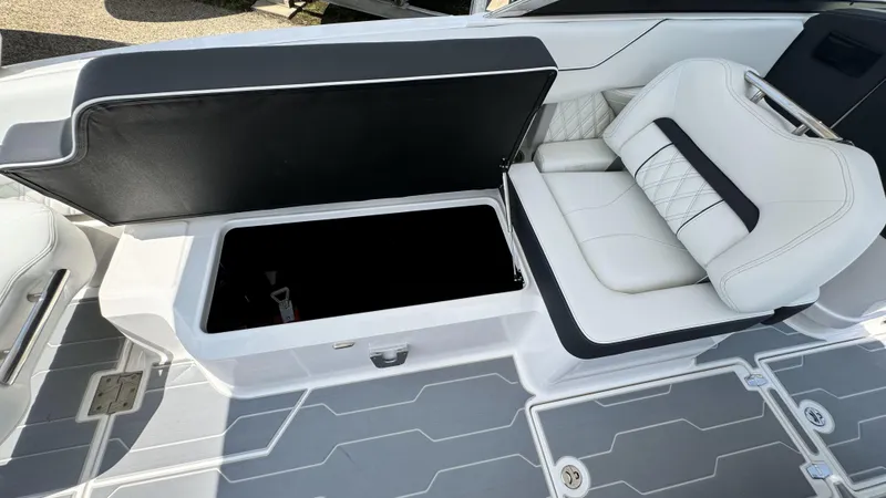 Slide: The Image of 2025 Regal LX6 boat with open storage compartment and white cushioned seating. - 21