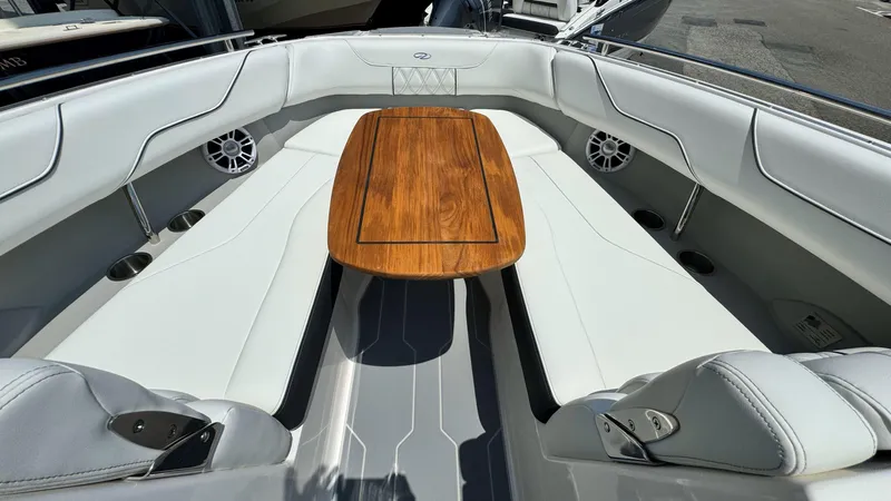 Slide: The Image of 2025 Regal LX6 boat interior with white seating and wooden table. - 34