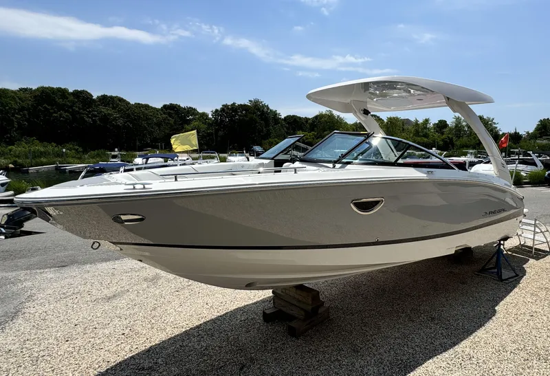 Slide: The Image of 2025 Regal LX6 boat displayed outdoors on a sunny day. - 5