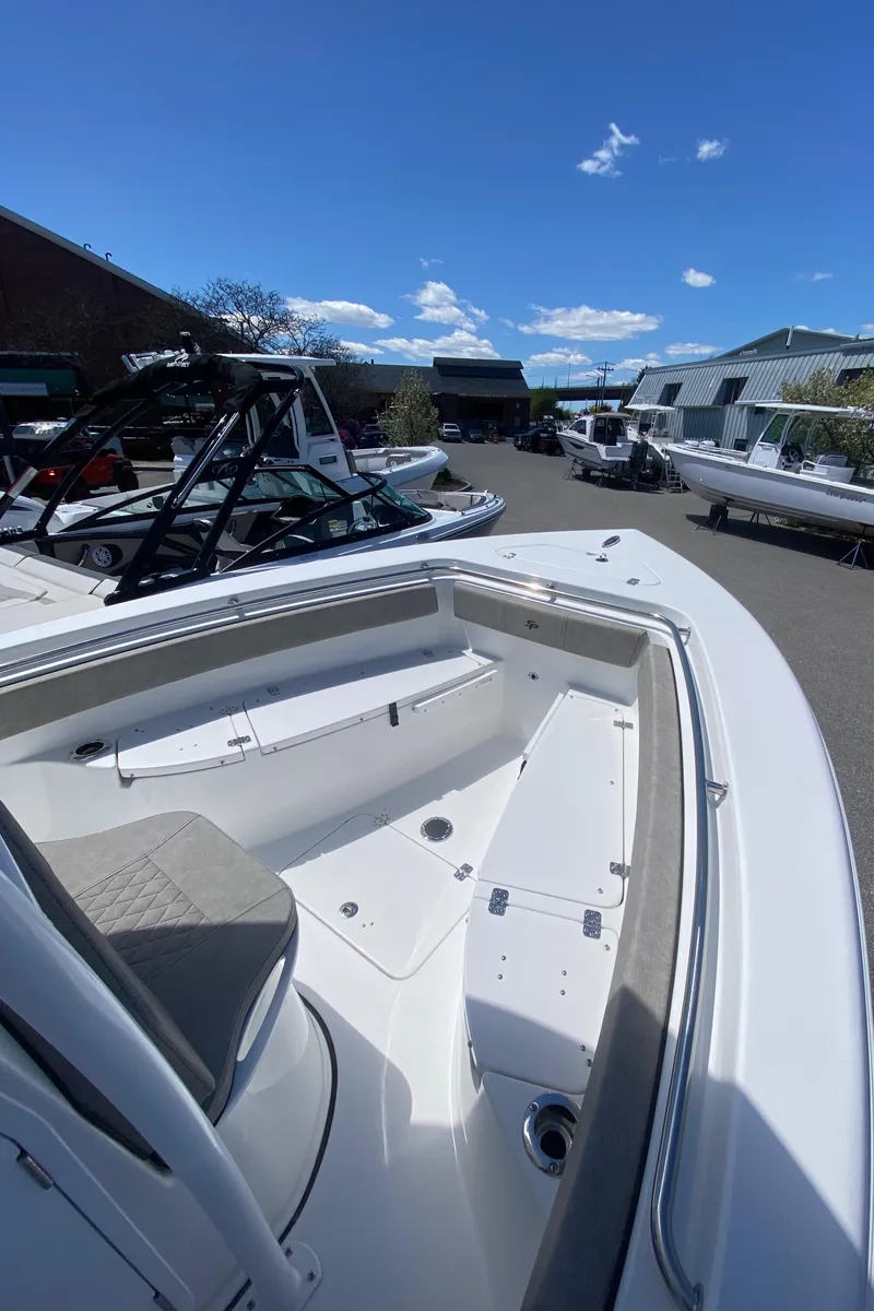 Slide: The Image of 2024 Sea Pro 222 Center Console boat with spacious deck and seating, docked under clear blue sky. - 11