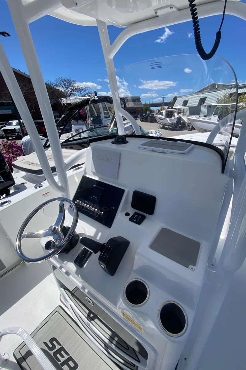 Slide: The Image of 2024 Sea Pro 222 Center Console boat dashboard with steering wheel and controls. - 8