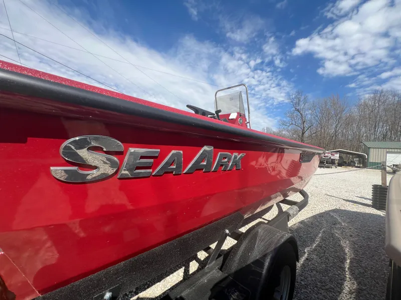 Slide: The Image of Red 2024 SeaArk 872 RX boat on trailer under blue sky. - 11
