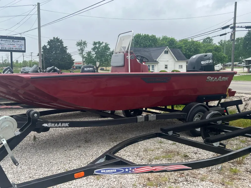 Slide: The Image of 2024 SeaArk 872 RX boat on trailer, red exterior, Suzuki engine, misty water background. - 3