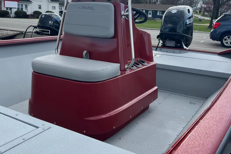 Slide: The Image of 2024 SeaArk 872 RX boat interior with red console and gray seating. - 7