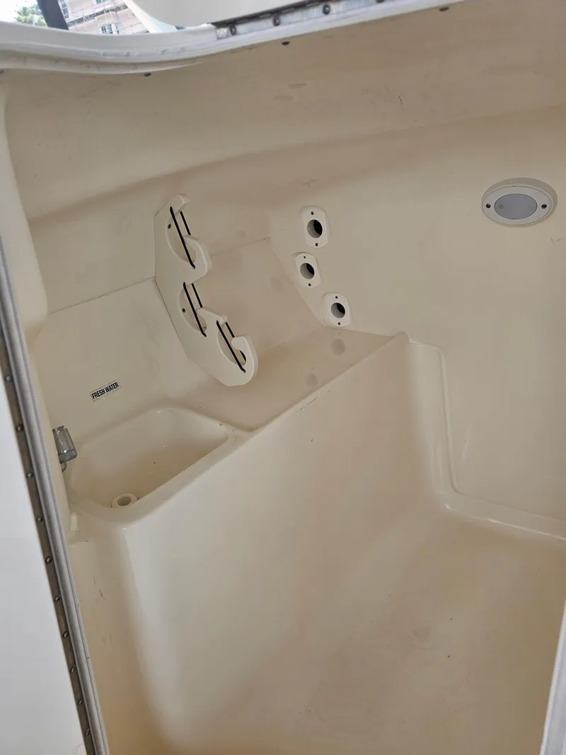 Slide: The Image of Interior of a 2021 Key West 239 DFS boat showing storage compartments and fresh water sink. - 24
