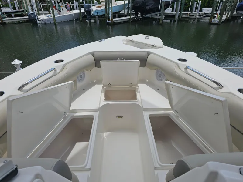 Slide: The Image of 2021 Key West 239 DFS boat with open storage compartments at the bow, docked by the water. - 8