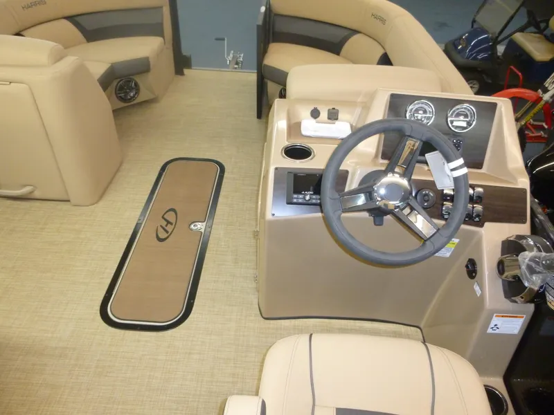 Slide: The Image of 2023 Harris FloteBote Cruiser 210 interior with beige seating and steering console. - 4
