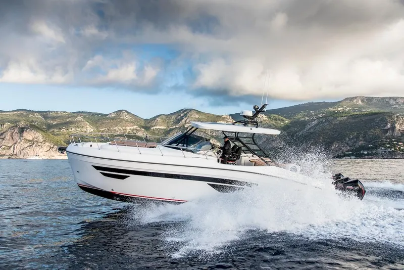 Slide: The Image of 2024 Oryx 379 boat cruising on the water with scenic mountain backdrop. - 5