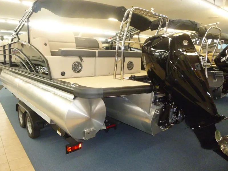 Slide: The Image of 2024 Harris Cruiser 230 Tritoon boat with powerful outboard motor on display. - 3