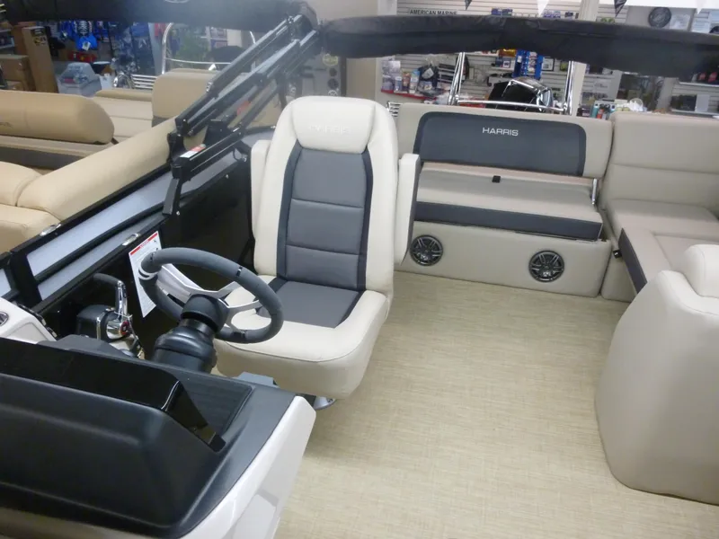 Slide: The Image of 2024 Harris Cruiser 230 Tritoon interior with beige and gray seating. - 5
