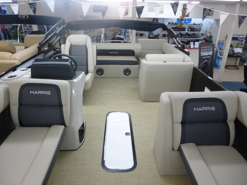 Slide: The Image of 2024 Harris Cruiser 230 Tritoon interior with beige and gray seating. - 7