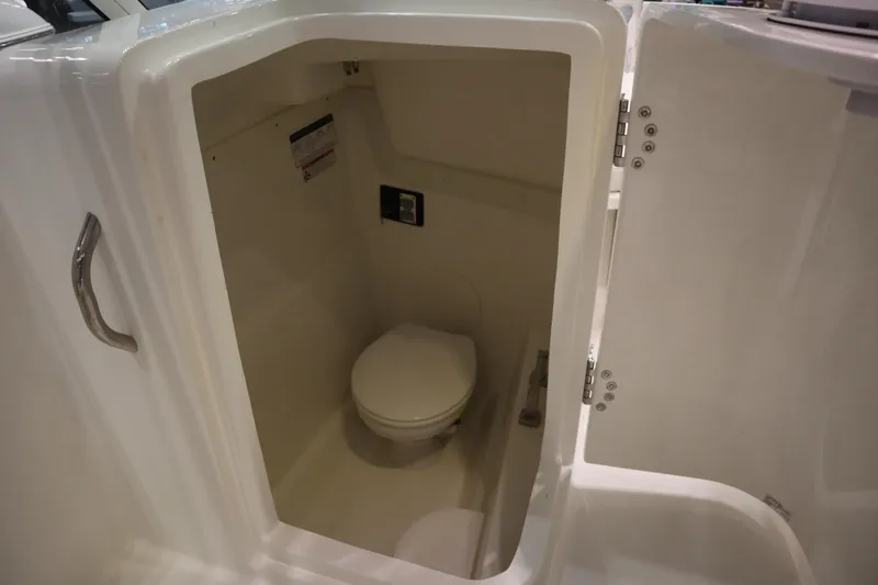 Slide: The Image of 2024 World Cat 230DC boat interior with compact marine toilet. - 10