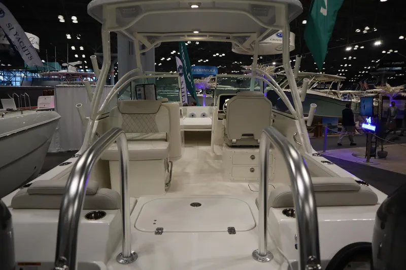 Slide: The Image of 2024 World Cat 230DC boat interior at a boat show, showcasing seating and helm area. - 13