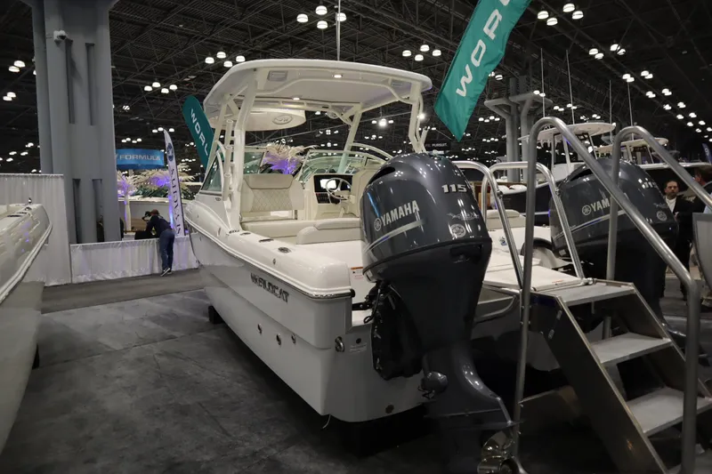 Slide: The Image of 2024 World Cat 230DC boat with Yamaha engine displayed at an indoor exhibition. - 2
