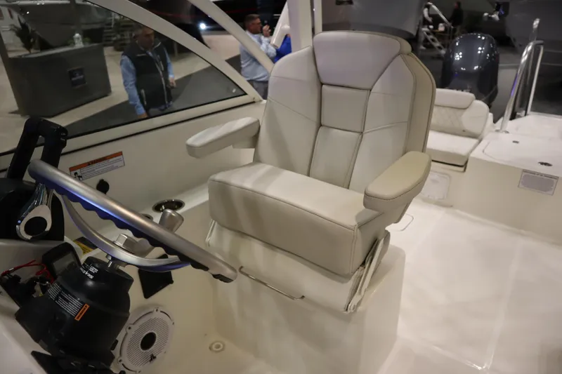 Slide: The Image of 2024 World Cat 230DC boat interior with captain's chair and steering wheel. - 8