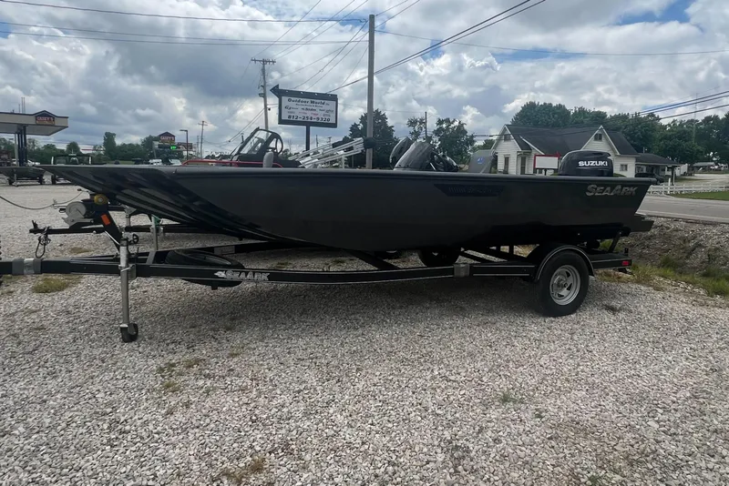 Slide: The Image of 2024 SeaArk 872 RX boat on a trailer in a gravel lot. - 0