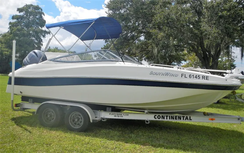 The Image of 2016 SouthWind 212 SD boat on a Continental trailer with blue canopy. - 1