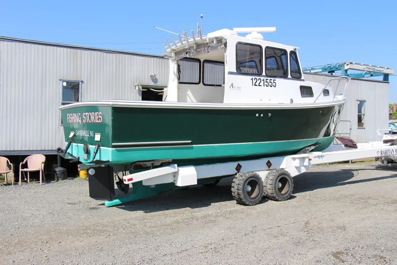 Slide: The Image of 2009 Custom Alley Boats 28 Downeast on trailer, green hull, docked on gravel. - 7