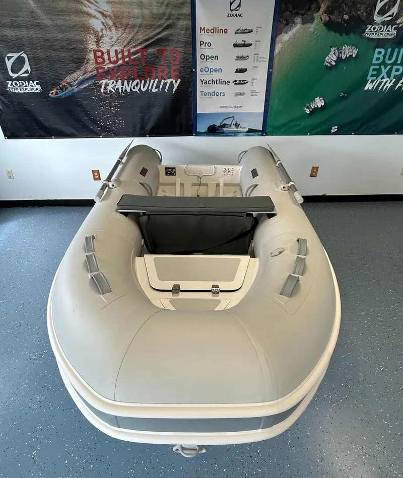 Slide: The Image of 2024 Zodiac Nomad RIB ALU 3.3 PVC inflatable boat displayed in showroom. - 2
