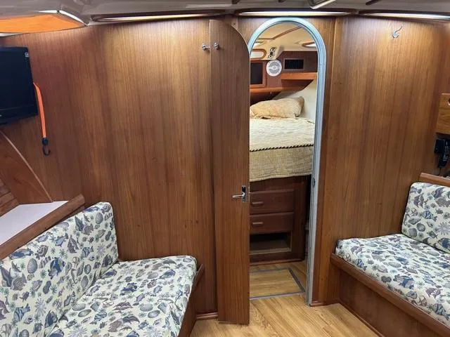 Slide: The Image of 1996 Luhrs 38 Open cabin interior with wood paneling and floral upholstery. - 10