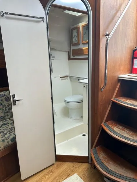 Slide: The Image of 1996 Luhrs 38 Open boat interior with bathroom, wooden stairs, and seating area. - 14
