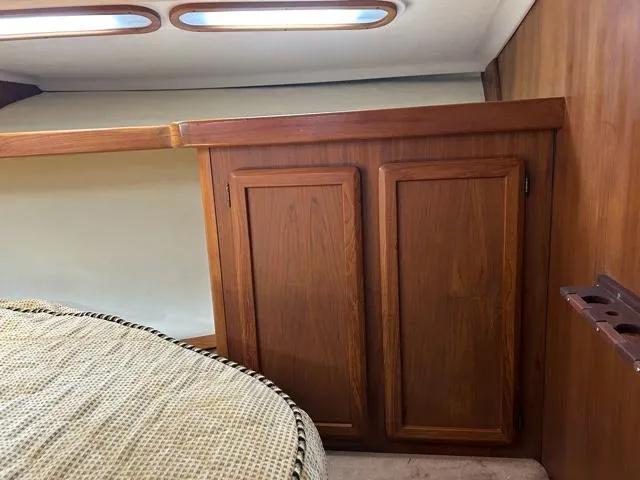 Slide: The Image of 1996 Luhrs 38 Open cabin interior with wooden cabinets and porthole windows. - 20