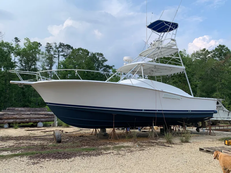 Slide: The Image of 1996 Luhrs 38 Open boat on dry dock with blue hull and white superstructure. - 6