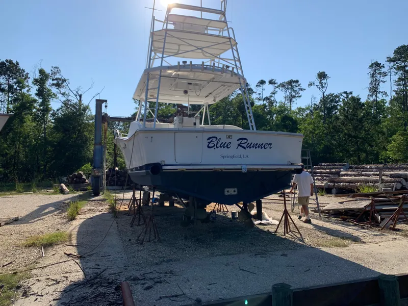 Slide: The Image of 1996 Luhrs 38 Open boat Blue Runner on dry dock in a wooded area. - 7