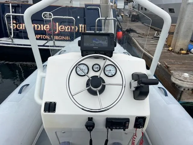 Slide: The Image of 2017 Highfield OM 500 boat dashboard with steering wheel, gauges, and navigation system. - 1