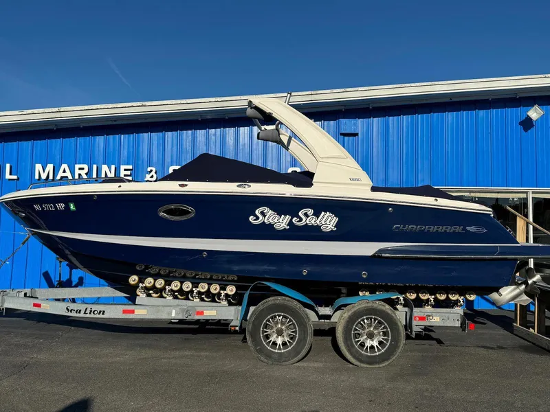 The Image of 2020 Chaparral 257 SSX boat on trailer in front of blue marine building. - 0