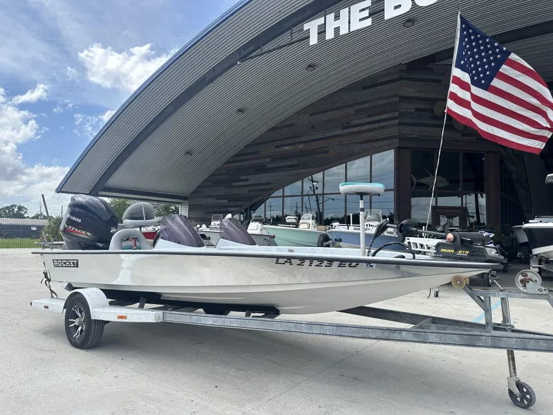 Slide: The Image of 1998 ROCKET 20 DC boat on trailer with American flag, outside a dealership. - 7