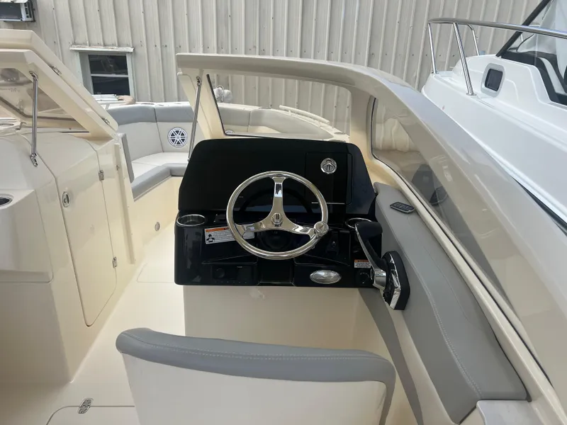 Slide: The Image of 2024 Scout 240 Dorado boat interior, featuring helm station and seating area. - 10