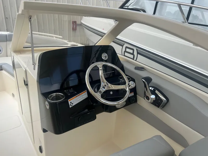 Slide: The Image of 2024 Scout 240 Dorado boat cockpit with steering wheel and control panel. - 11