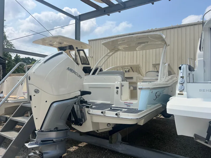 Slide: The Image of 2024 Scout 240 Dorado boat with Mercury outboard engine, docked outdoors. - 2