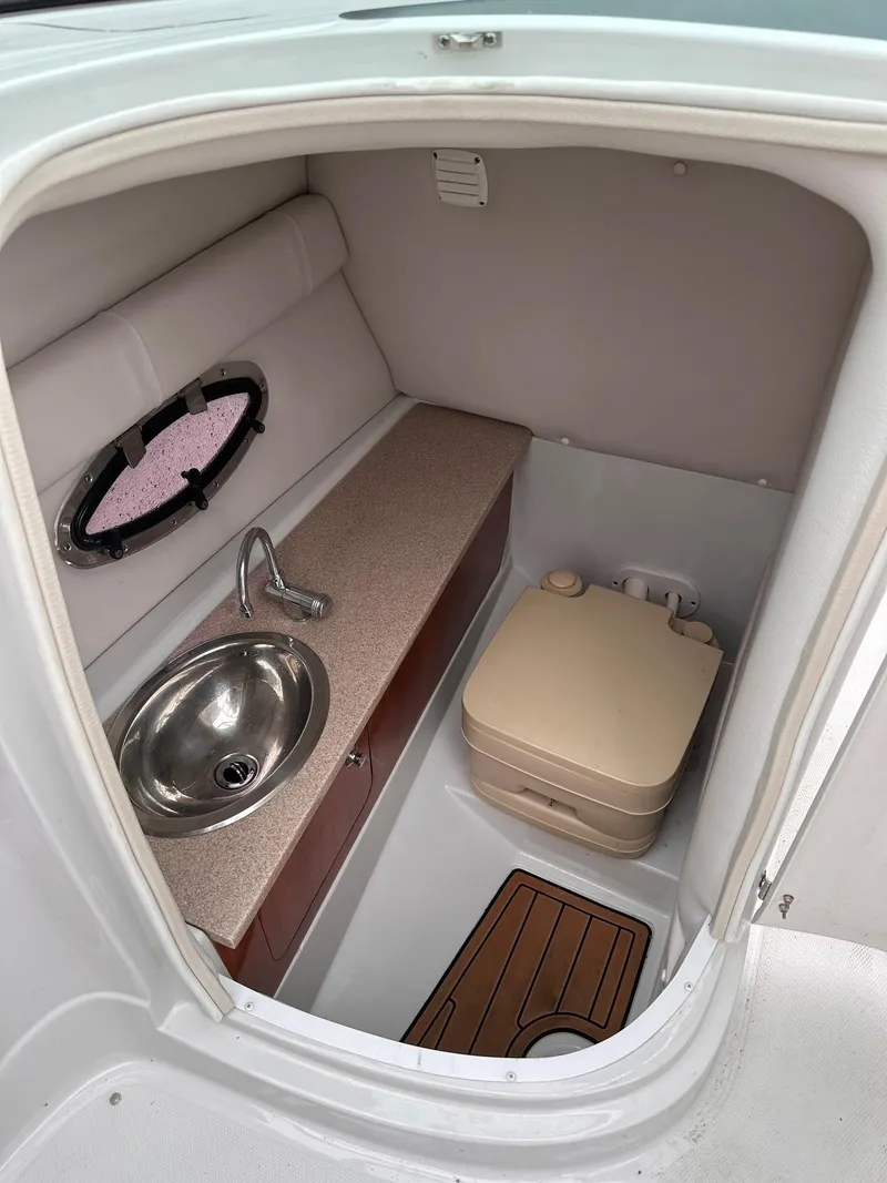 Slide: The Image of 2014 Crownline 255 SS boat interior with sink and portable toilet. - 2