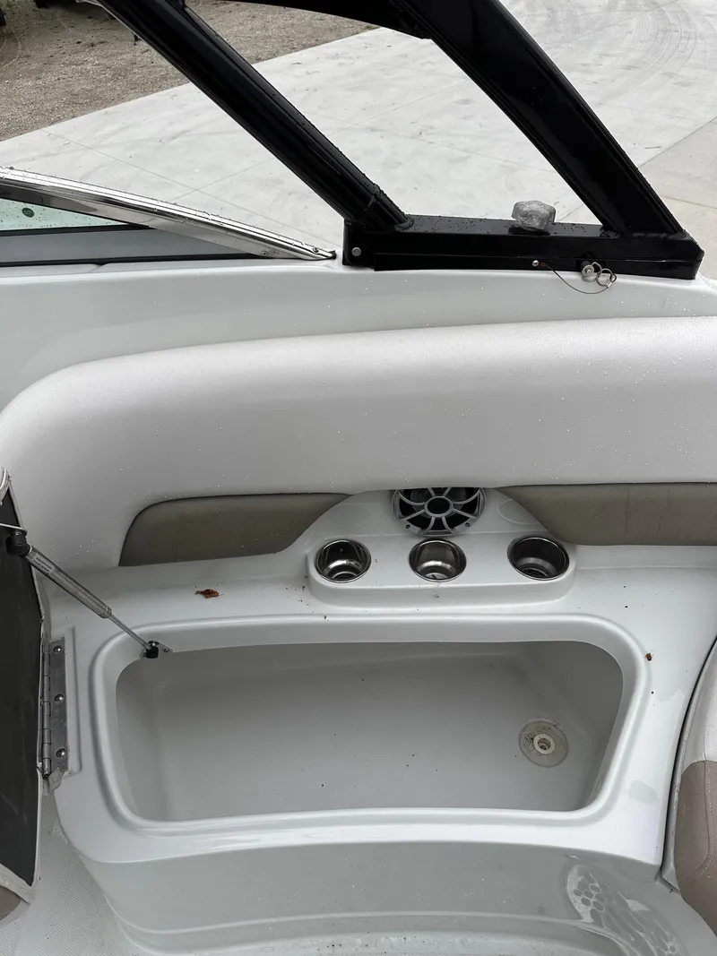 Slide: The Image of 2014 Crownline 255 SS boat interior with storage compartment and cup holders. - 6